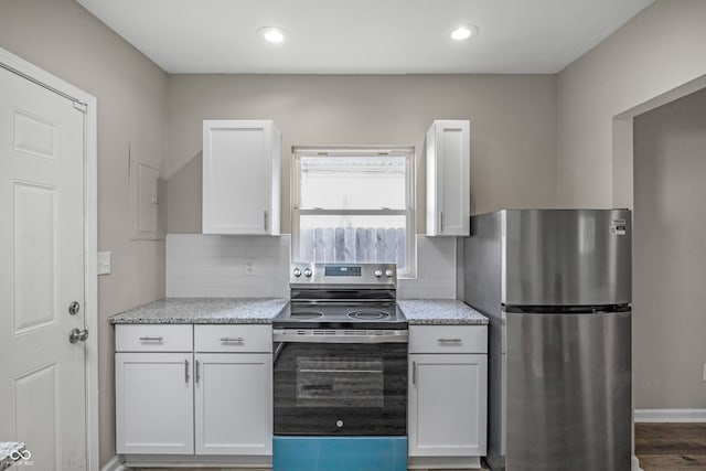 kitchen featuring white cabinets, decorative backsplash, hardwood / wood-style floors, and stainless steel appliances