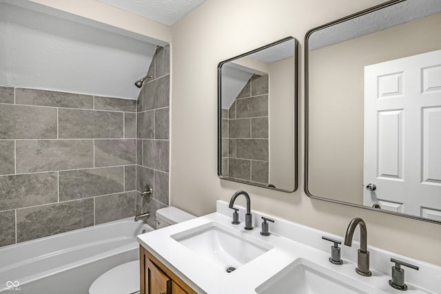 full bathroom featuring tiled shower / bath combo, toilet, and vanity