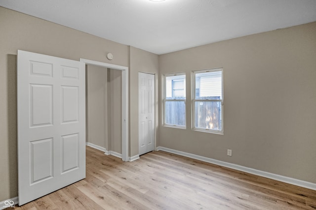 unfurnished bedroom with light hardwood / wood-style floors and a closet