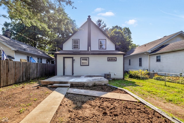 back of house with central AC, a patio area, and a lawn