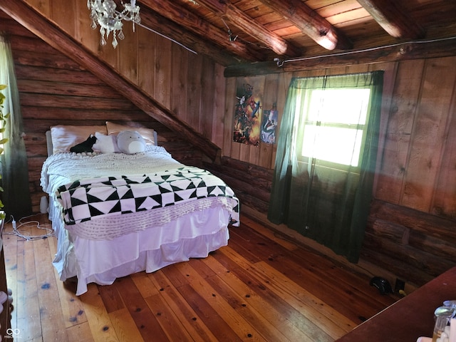 bedroom with wooden ceiling, wood walls, wood finished floors, log walls, and beamed ceiling