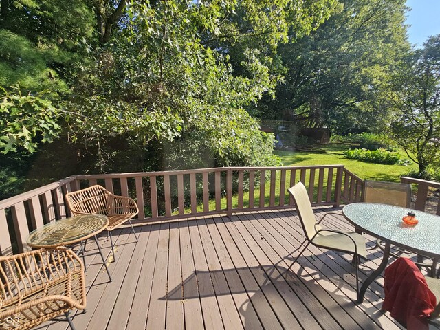 wooden terrace featuring a yard