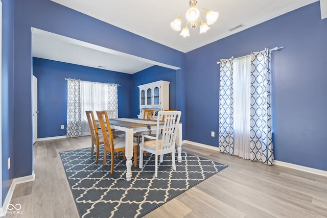 dining room featuring hardwood / wood-style floors and a notable chandelier