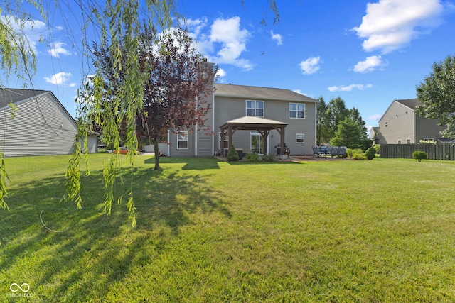 rear view of house with a lawn and a gazebo