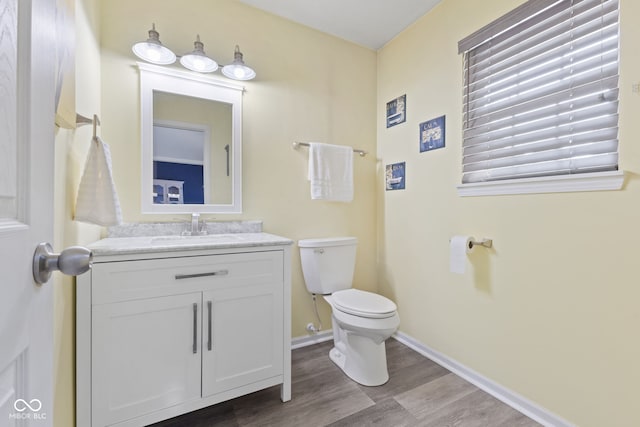 bathroom featuring toilet, hardwood / wood-style floors, and vanity