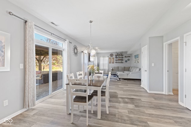 dining space featuring light hardwood / wood-style floors and a notable chandelier