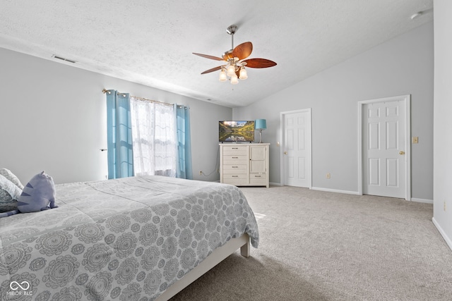 carpeted bedroom featuring vaulted ceiling, ceiling fan, and a textured ceiling