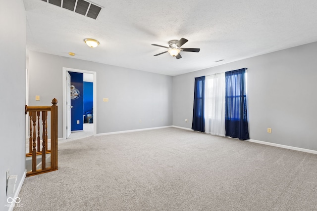 spare room with a textured ceiling, ceiling fan, and carpet flooring