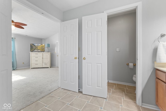 bathroom featuring ceiling fan, vanity, vaulted ceiling, and toilet