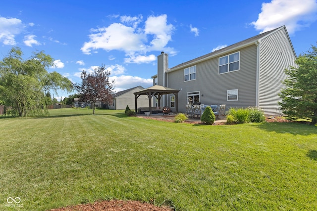 rear view of property featuring a gazebo, a patio area, and a yard