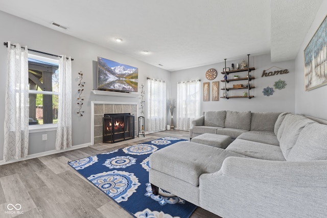 living room featuring hardwood / wood-style flooring and a tile fireplace