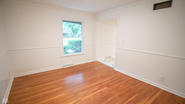 unfurnished room featuring ornamental molding and wood-type flooring