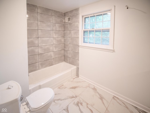 bathroom featuring tiled shower / bath combo and toilet