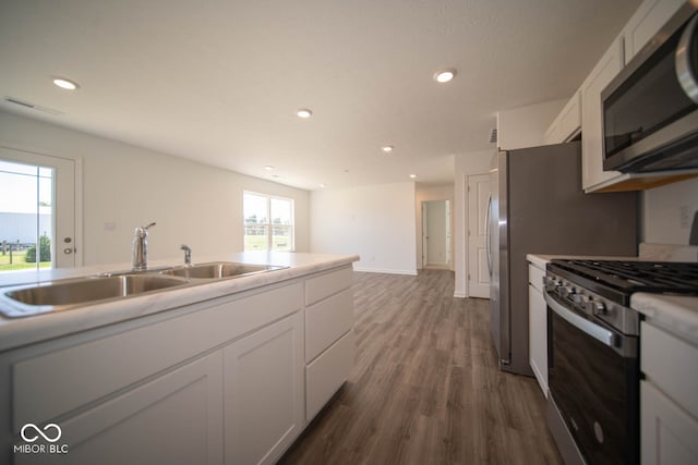 kitchen featuring stainless steel appliances, dark hardwood / wood-style flooring, sink, and white cabinets