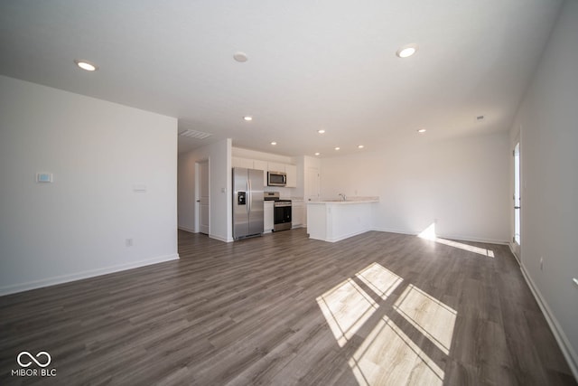 unfurnished living room with sink and dark wood-type flooring