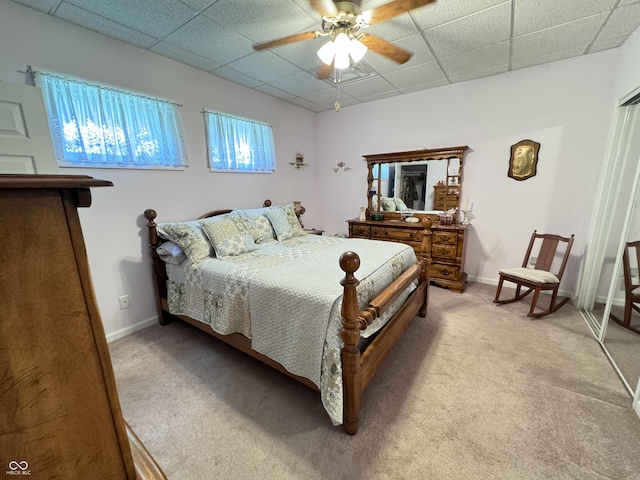 carpeted bedroom with a drop ceiling and ceiling fan