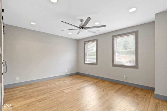 spare room with ceiling fan and light wood-type flooring