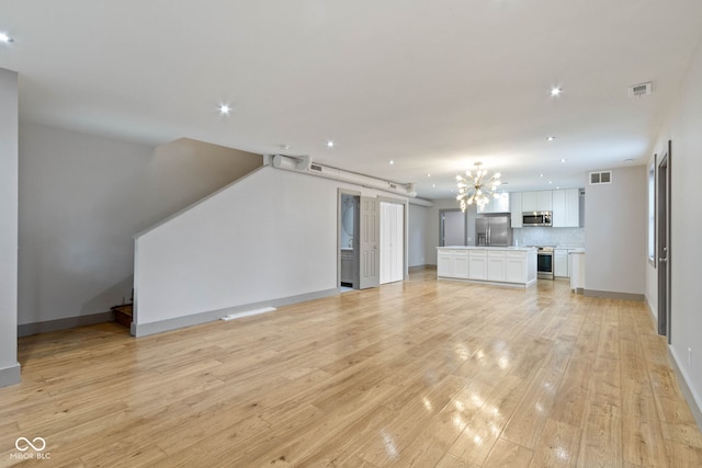 unfurnished living room featuring light hardwood / wood-style floors and a barn door