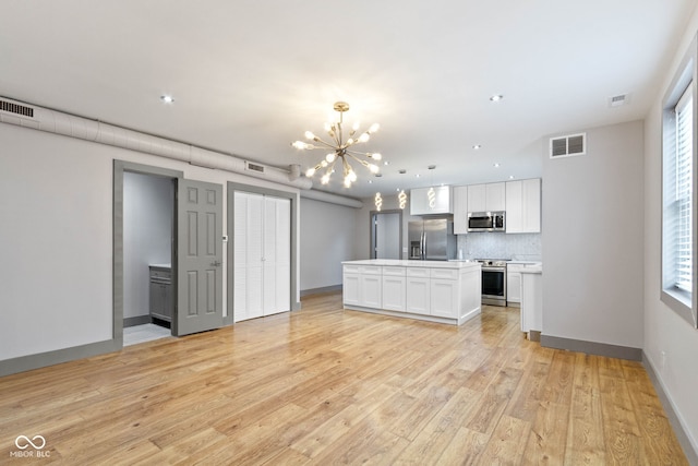 unfurnished living room featuring light hardwood / wood-style flooring and a chandelier