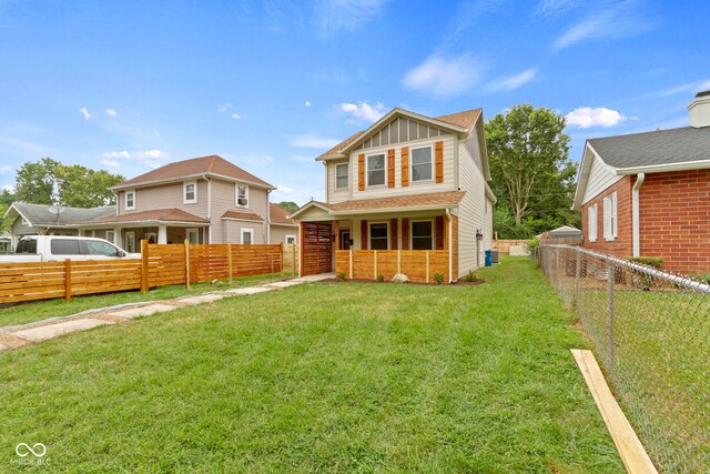 rear view of property featuring a lawn