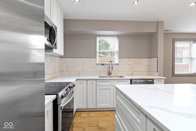 4513 Norwaldo Ave, Indianapolis, IN 46205 - kitchen featuring sink, stainless steel appliances, white cabinets, and light stone countertops