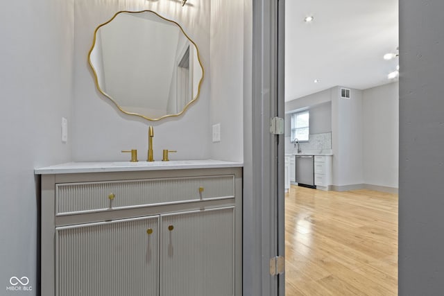 bathroom featuring hardwood / wood-style flooring, tasteful backsplash, and vanity