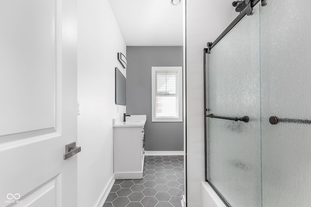 bathroom featuring tile patterned flooring, combined bath / shower with glass door, and vanity