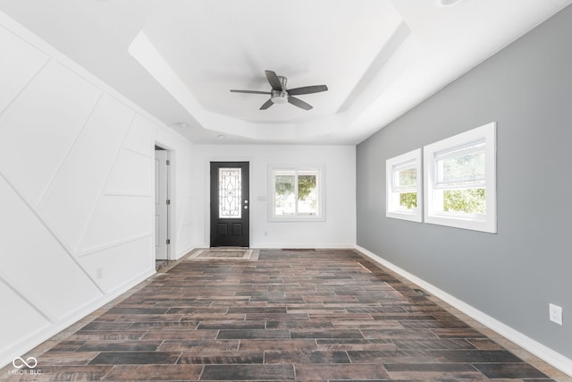 entryway with ceiling fan and a tray ceiling