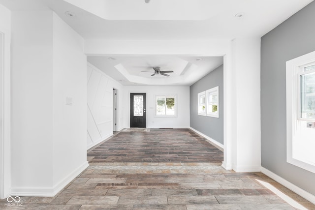 entryway featuring a raised ceiling, hardwood / wood-style floors, and ceiling fan