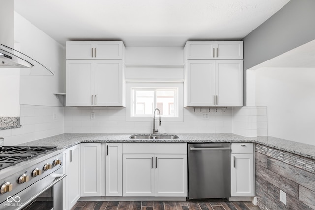 kitchen with dishwasher, backsplash, wall chimney exhaust hood, and sink