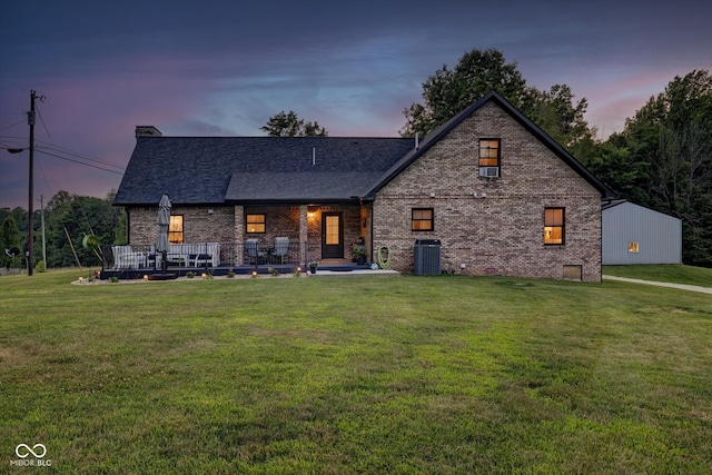 view of front of home featuring central AC and a lawn