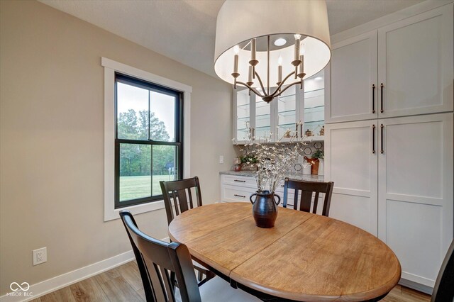 dining area featuring light wood-type flooring and an inviting chandelier