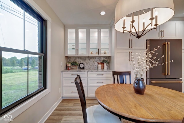 dining area with light hardwood / wood-style flooring and a notable chandelier