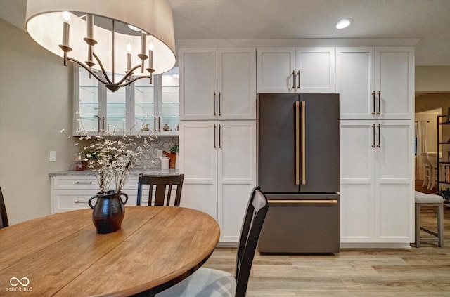 dining room featuring light wood-type flooring and a chandelier