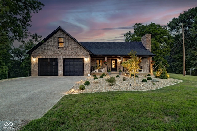 view of front of home featuring a garage, a porch, and a yard