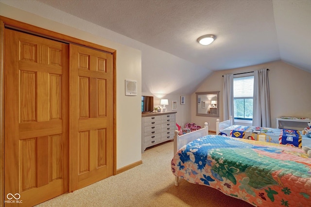 bedroom featuring light colored carpet, lofted ceiling, and a textured ceiling