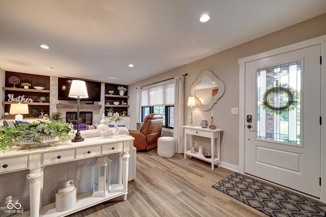 entryway with a large fireplace and light wood-type flooring