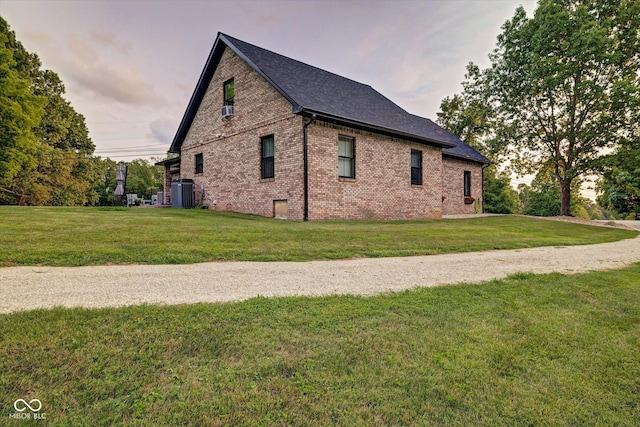 property exterior at dusk with a lawn