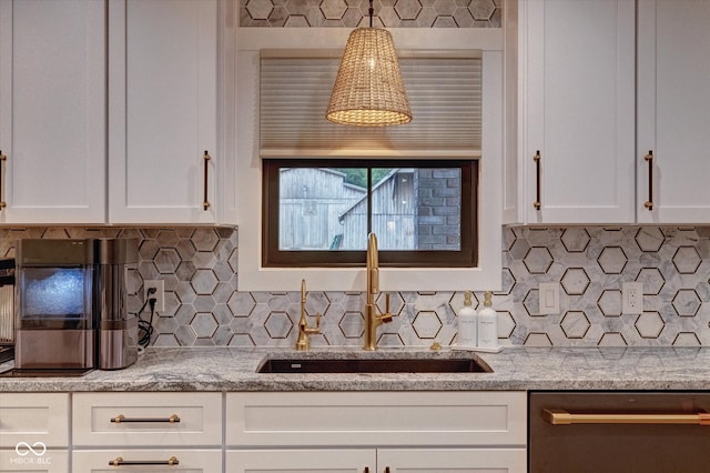 kitchen featuring backsplash, sink, stainless steel dishwasher, decorative light fixtures, and white cabinetry