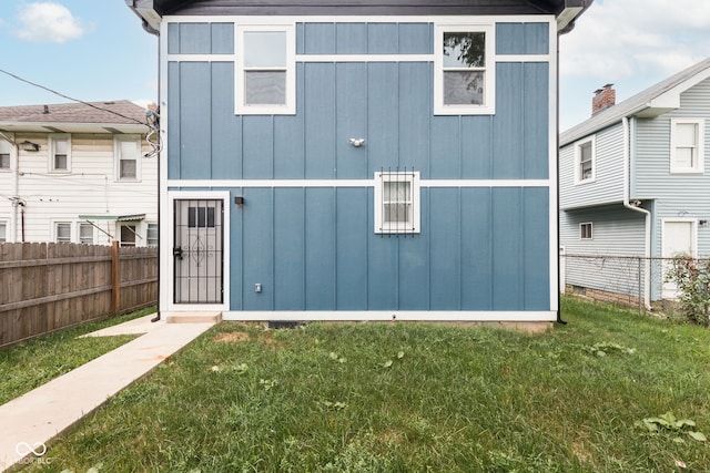 rear view of property featuring a yard