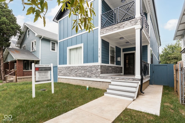 exterior space featuring a balcony and a lawn