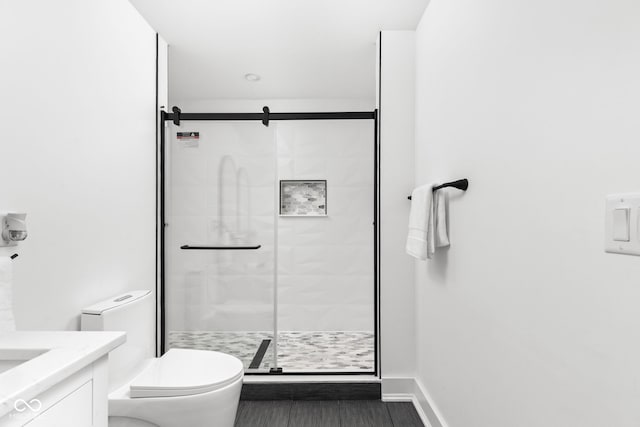 bathroom with toilet, vanity, a shower with shower door, and tile patterned flooring