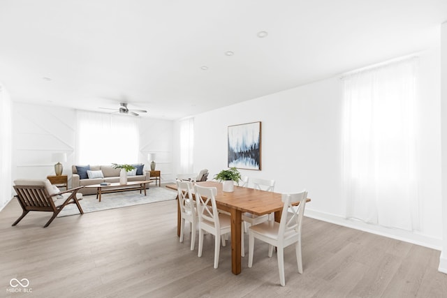 dining space with light wood-type flooring and ceiling fan