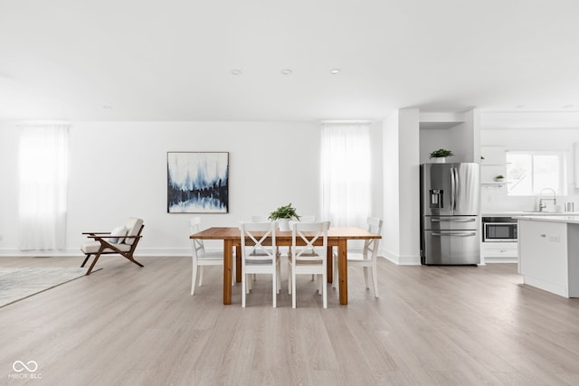 dining space featuring light hardwood / wood-style flooring and sink