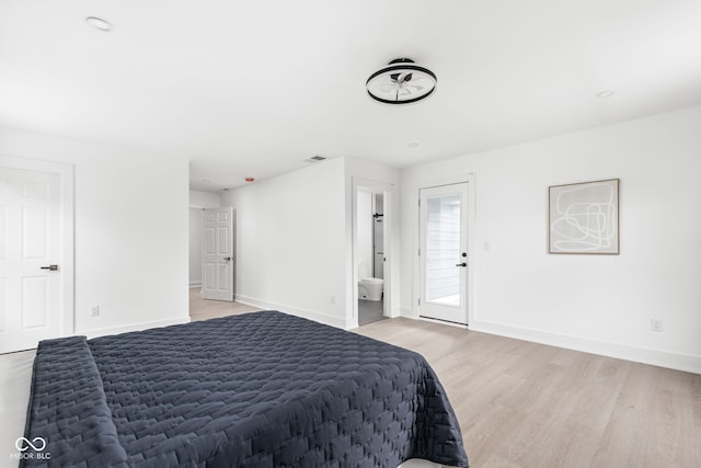 bedroom featuring ensuite bath and light wood-type flooring