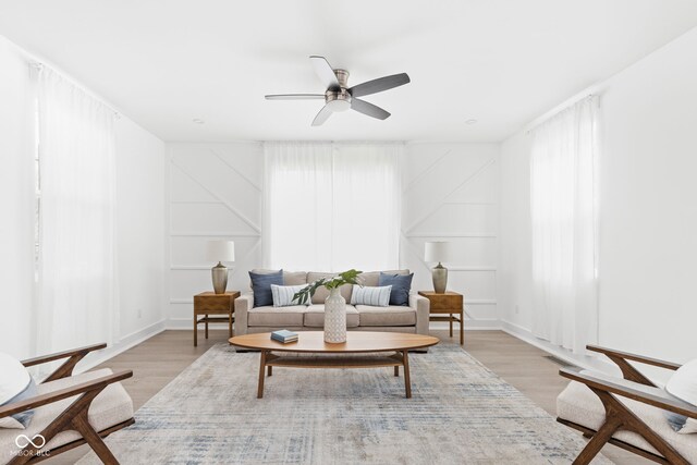 living room featuring light hardwood / wood-style flooring and ceiling fan