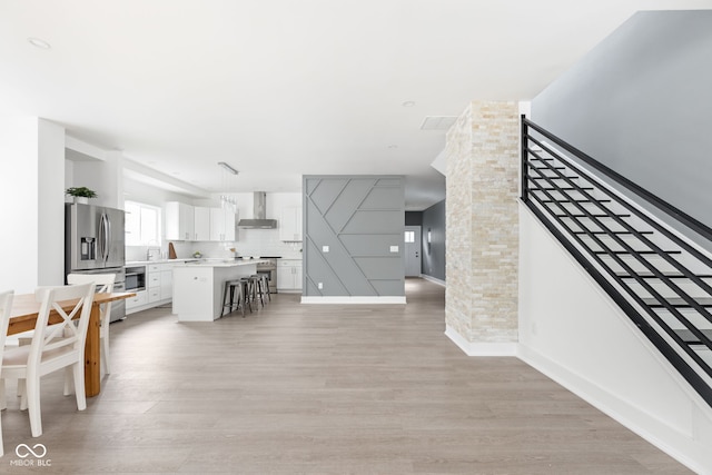 living room with brick wall and light hardwood / wood-style floors