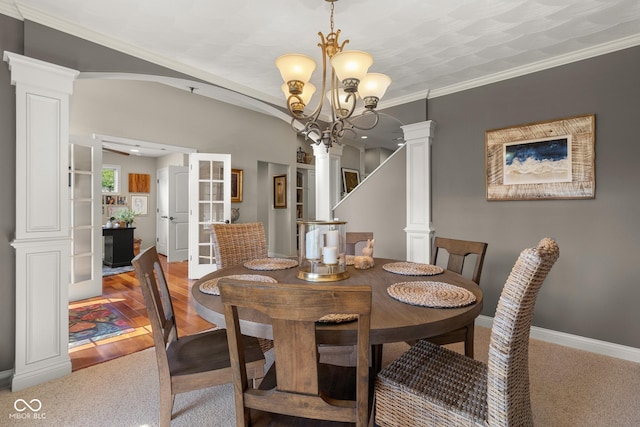 dining area with decorative columns, crown molding, and a notable chandelier