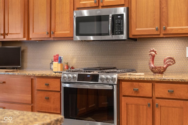 kitchen with decorative backsplash, light stone countertops, and stainless steel appliances