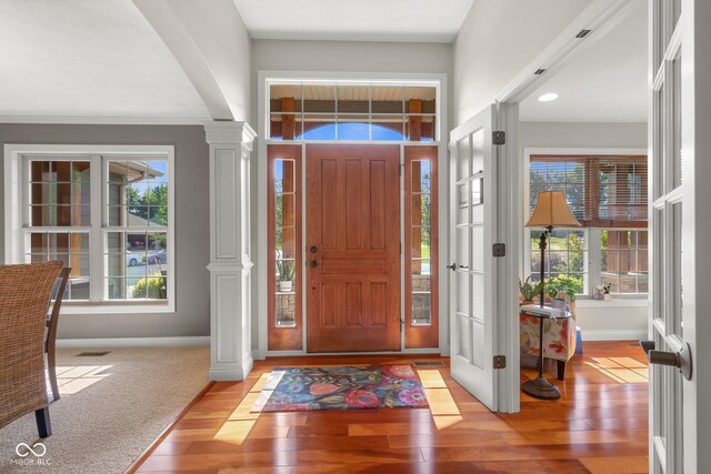 entrance foyer with light hardwood / wood-style flooring and ornate columns